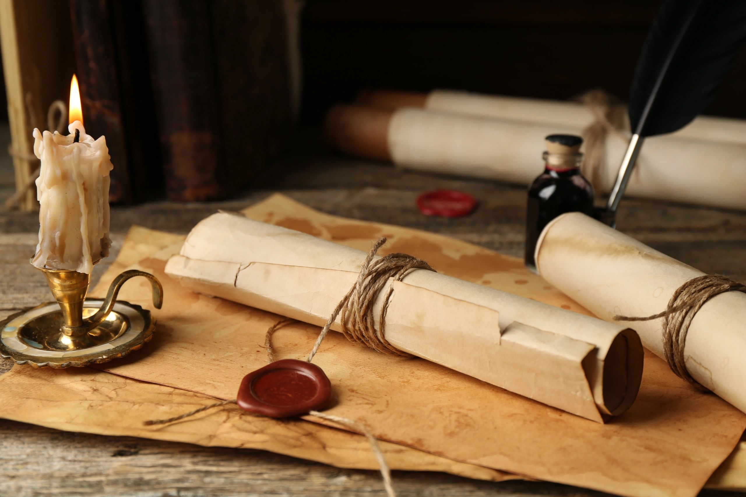 Historic documents and candle on a wooden table