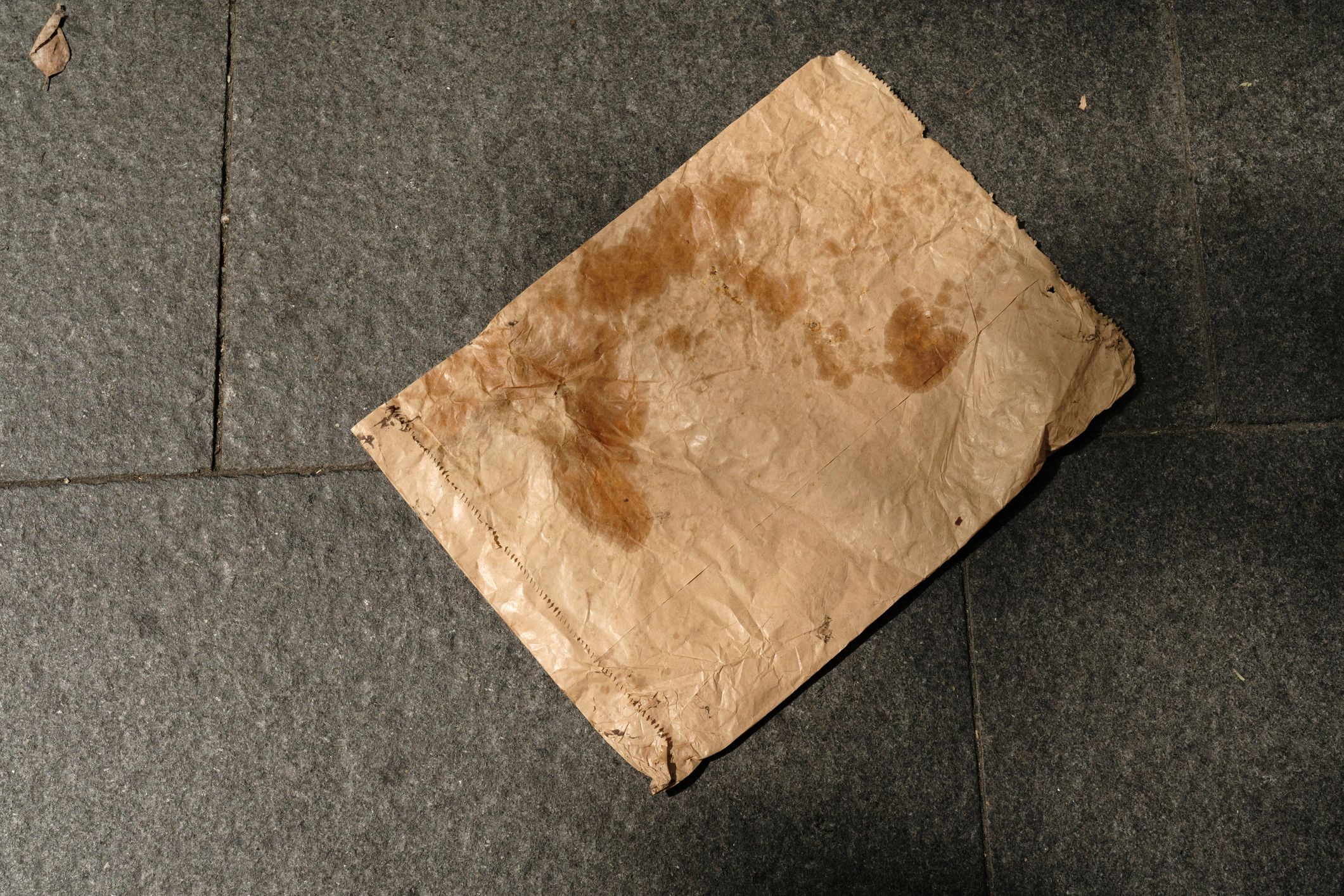 Discarded paper evidence bag on the ground